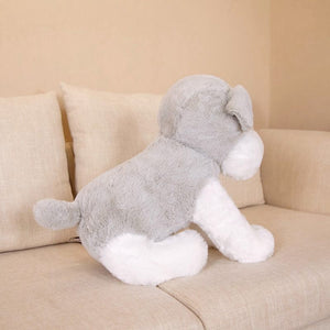 this image shows the the back of the Cutest Schnauzer Stuffed Animal Plush Toy sitting on the sofa looking adorable.