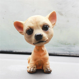 Image of a sitting chihuahua bobblehead - on a car dashboard