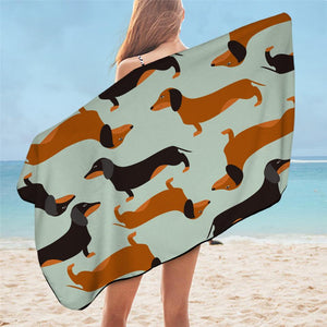 Image of a girl holding a dachshund beach towel with brown and black dachshunds on it