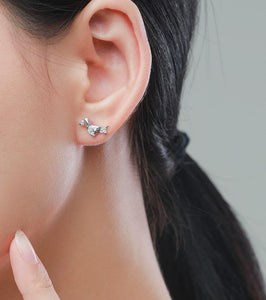 Image of a lady wearing silver stone studded dachshund earrings