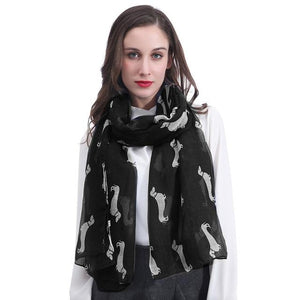Image of a girl wearing a beautful Dachshund scarf in the color black with infinite Dachshunds design