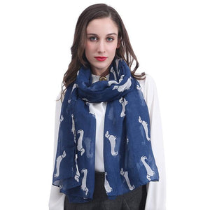 Image of a girl wearing a beautful Dachshund scarf in the color navy blue with infinite Dachshunds design