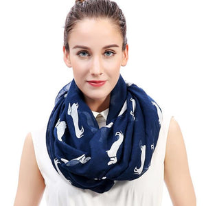 Image of a girl wearing a beautful Dachshund scarf in the color navy blue with infinite Dachshunds design