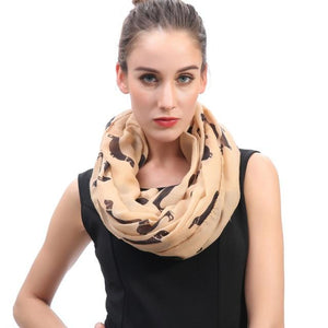 Image of a girl wearing a beautful Dachshund scarf in the color tan with infinite Dachshunds design