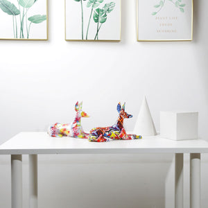 Image of two stunning multicolor doberman statues on a white table