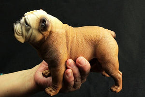Image of a cutest brown color English Bulldog figurine in the hand of a person