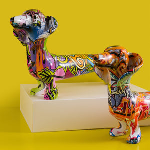 Image of a close view of two multicolor extra long graffiti dachshund statues