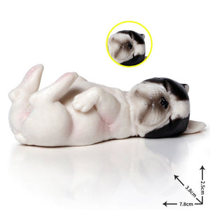 Image of a miniature sleeping on back french bulldog figurine in the color pied black and white