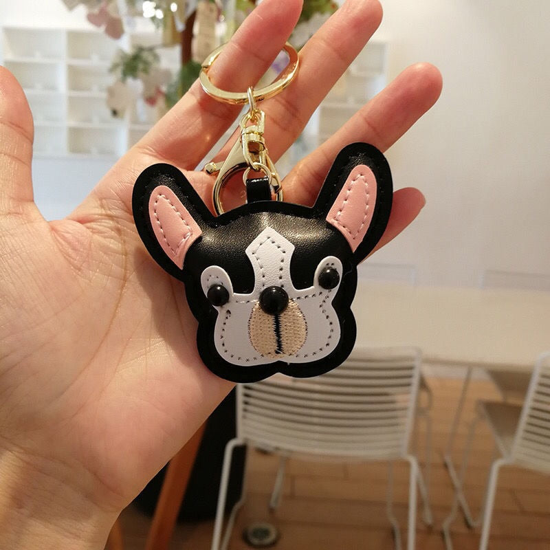 Image of a person holding black color french bulldog keychain made of PU leather