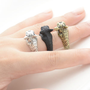 Image of three french bulldog wrap rings on the finger of a person in three colors including Antique Silver, Bronze, and Black Gunmetal
