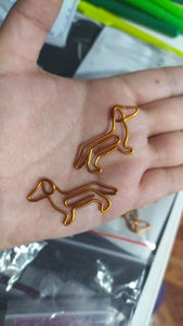image of person holding dachshund paperclips in hand