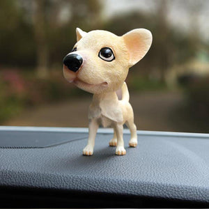 Image of a standing Chihuahua bobblehead on a car dashboard