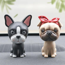 Load image into Gallery viewer, Image of two nodding bobbleheads on a car dashboard shaped like a Boston Terrier and a girl Pug