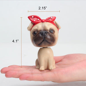Image of a nodding girl Pug bobblehead on the hand of a person