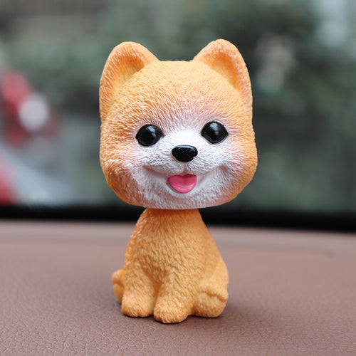 Image of a smiling pomeranian bobblehead in the color orange