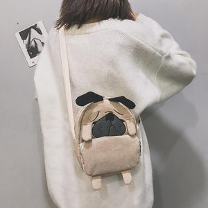 Back image of a lady holding pug messenger bag in the color Khaki