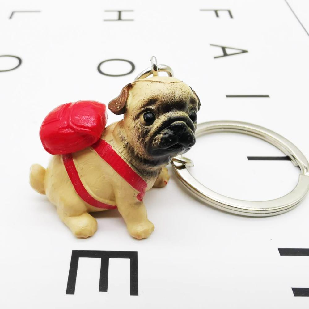 Image of an adorable Pug keychain wearing a red backpack