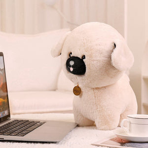 image of an adorable pug stuffed animal pug plush toy sitting on a table in front of a laptop