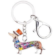 Load image into Gallery viewer, Image of an adorable orange color enamel Dachshund keychain wearing hat, made of enamel