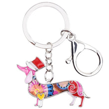 Load image into Gallery viewer, Image of an adorable pink color enamel Dachshund keychain wearing hat, made of enamel